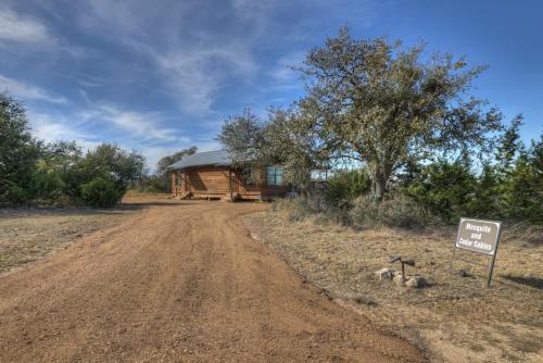 a log cabin on the side of a dirt road at Rocky Ridge Cedar Cabin with Hot Tub & Amazing Views in Crabapple