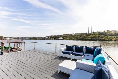 a wooden deck with two couches on the water at Lakefront Paradise with Firepit in Meadowlakes