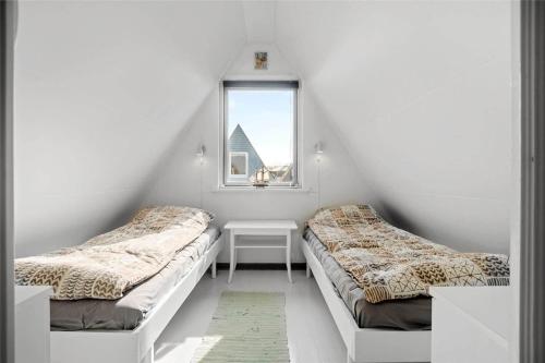 two beds in a white room with a window at M132-Gedser-Gedser-Feriepark-50 in Gedser