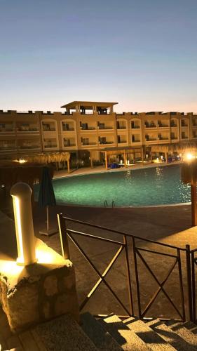 a large building with a swimming pool in front of it at Bay View Resort Sahl Hashesh in Hurghada
