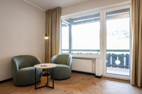 a room with two chairs and a table and a window at May Hotel Mayschoß in Mayschoß