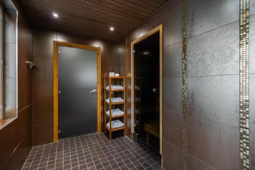baño con ducha a ras de suelo y puerta en Riverside Luxury Retreat By BookLapland, en Rovaniemi