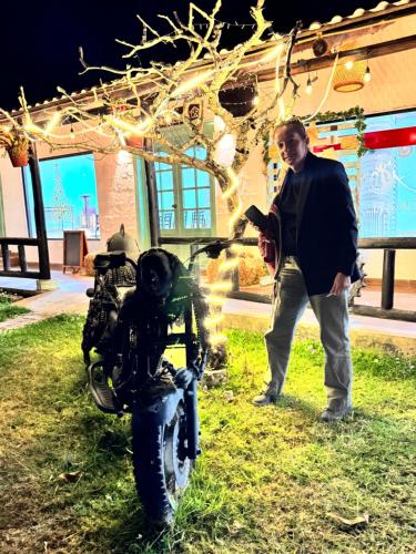 a man is standing next to a motorcycle at Finca San Alejandro in Cotacachi