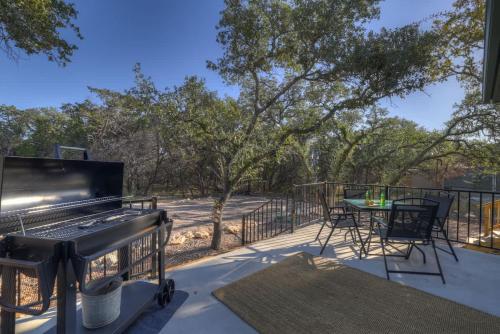 a patio with a grill and a table and chairs at Serene Guadalupe River Getaway-River Access! in Cranes Mill