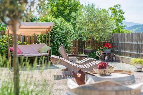 a backyard with a bench and an umbrella and a table at Haus Karin living in Brixen
