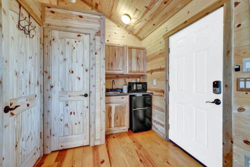 a kitchen with wooden walls and a white door at Rocky Ridge Cedar Cabin with Hot Tub & Amazing Views in Crabapple
