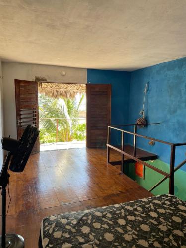 a bedroom with a bed and a blue wall at Casa Zion Land in Canoa Quebrada