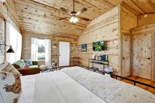 a bedroom with a large bed in a room with wooden walls at Rocky Ridge Cedar Cabin with Hot Tub & Amazing Views in Crabapple