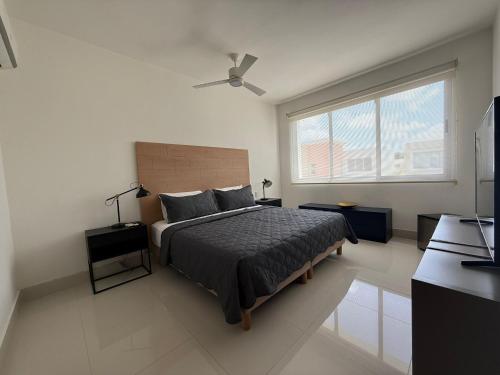 a bedroom with a bed and a large window at Luxury Villa Pool and BBQ in San Juan Lakes Los Colales RD in Punta Cana