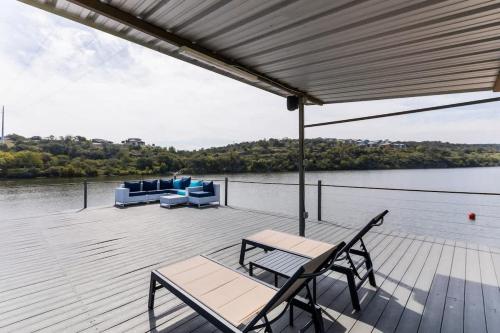 a wooden deck with a table and chairs on a body of water at Lakefront Paradise with Firepit in Meadowlakes