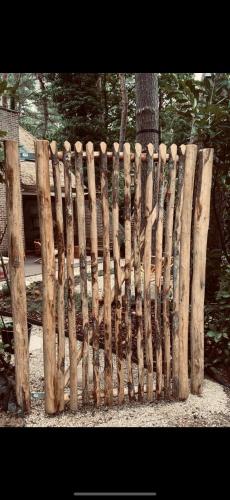 a wooden fence in front of a tree at Five Trees Forest Home in Lanaken