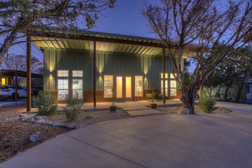 a home with a large glass building with a tree at Serene Guadalupe River Getaway-River Access! in Cranes Mill