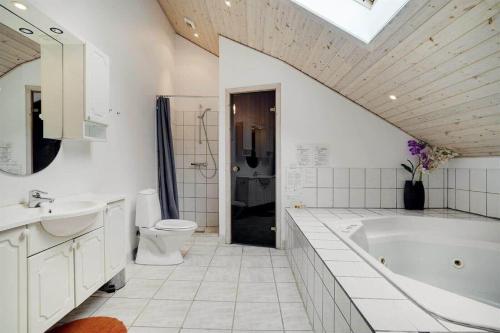 un bagno con vasca, WC e lavandino di M324-Vaeggerlose-Baeverstien-10 a Bøtø By
