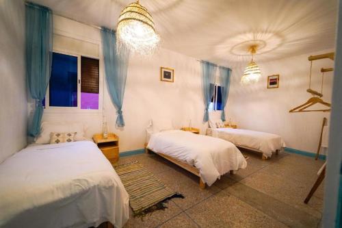 a bedroom with two beds and two windows at Anza sets house in Agadir