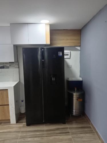 a kitchen with a black refrigerator in a room at CASA APARTAMENTO COMPLETO THOMY - Coveñas in Coveñas