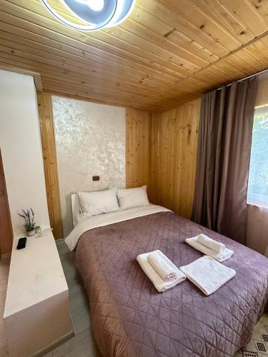 a bedroom with a large bed with towels on it at Pink House Karpaty in Krivorovnya