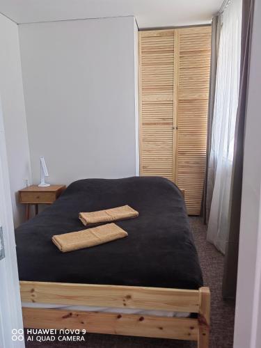a bedroom with a bed with two towels on it at Next door airport apartment in Karmėlava