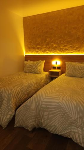 two beds sitting next to each other in a room at Paraíso Plaza - Hotel Boutique in Aguadas