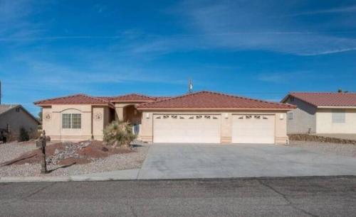 a large house with a garage in front of it at Paradise home with king bed & room for the family in Lake Havasu City