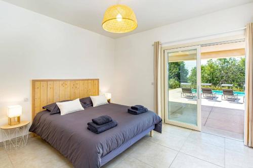 a bedroom with a bed and a balcony with chairs at Villa Diamant by Villa Plus in Saint-Cézaire-sur-Siagne