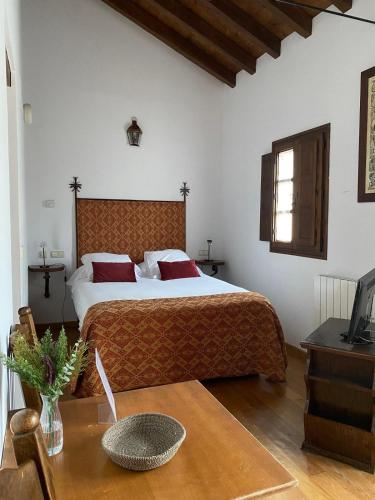 a bedroom with a bed and a table and a television at Palacio Rejadorada in Toro