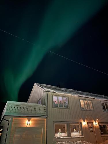 a house with the northern lights in the sky at Northern Dream Lofoten in Hovdan