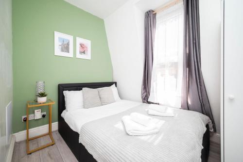 a bedroom with a bed with two towels on it at Strand Central Apartments 4th Floor in London