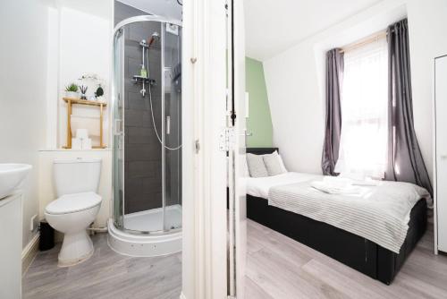 a small bathroom with a bed and a shower at Strand Central Apartments 4th Floor in London
