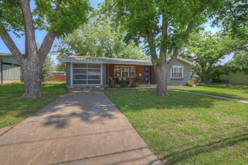 a house with trees in front of a yard at Luxury Mid Century Charmer Near Historic Main St in Fredericksburg