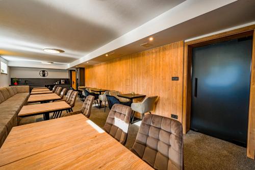 a restaurant with wooden walls and tables and chairs at PENZIÓN u JAKUBA & REŠTAURÁCIA Bezplatné Parkovanie in Martin