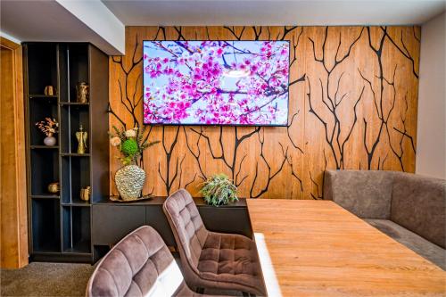 a dining room with a table and a television on a wall at PENZIÓN u JAKUBA & REŠTAURÁCIA Bezplatné Parkovanie in Martin