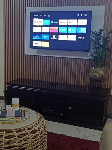 TV de pantalla plana en la parte superior de un piano en Nelspruit holiday house, en Mataffin