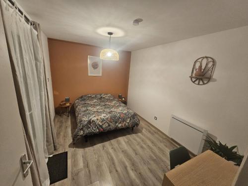 a bedroom with a bed and a table in it at Le Loft du Monchelet, 2 pièces - Saint-Omer in Pihem