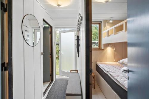 a small room with a bed and a mirror at M225-Idestrup-Jasminvej-22 in Bøtø By