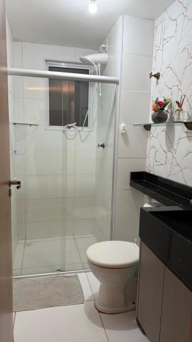 a bathroom with a toilet and a glass shower at Studio 06 in Caruaru