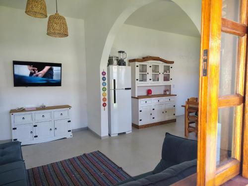 a living room with a refrigerator and a table at Recanto com piscina em Caraguatatuba - São Sebastião in Caraguatatuba