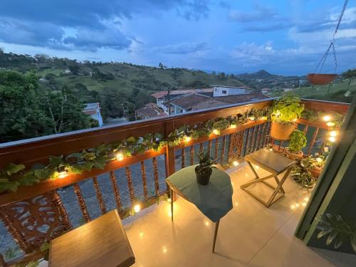a balcony with a table and chairs and lights at Blomst Casa Hostal in Jericó