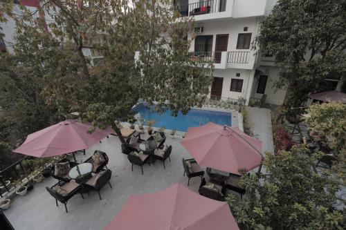 an overhead view of a patio with chairs and umbrellas at Yogved Hospitality & Resort in Rishīkesh