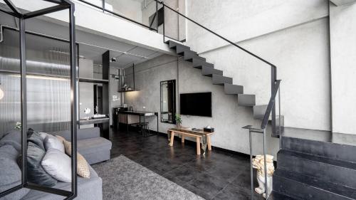 a living room with a staircase in a loft at Palette The Ex Capital Hotel Bangkok in Bangkok
