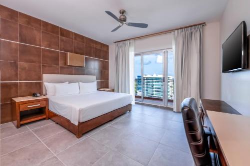 a hotel room with a bed and a tv at Krystal Urban Cancun & Beach Club in Cancún