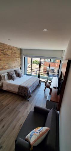 a bedroom with a large bed and a couch at PARDO Boutique in Bogotá