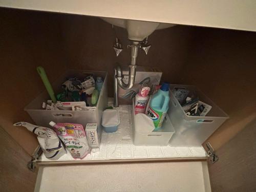 a bathroom sink with toothbrushes and toiletries under a sink at Atami Umine Villa in Atami