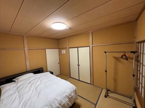 a bedroom with a bed and a light on the ceiling at Atami Umine Villa in Atami