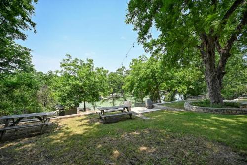 two picnic benches in a park with a tree at Luxury Lakefront Oasis with Boat Dock-Firepit in McQueeney