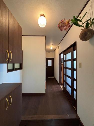 a hallway of a kitchen with a door to a room at Atami Umine Villa in Atami