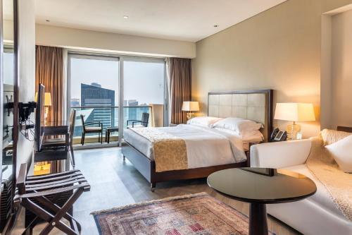 a bedroom with a bed and a living room with a balcony at Seaview & Marina View Studio in Dubai