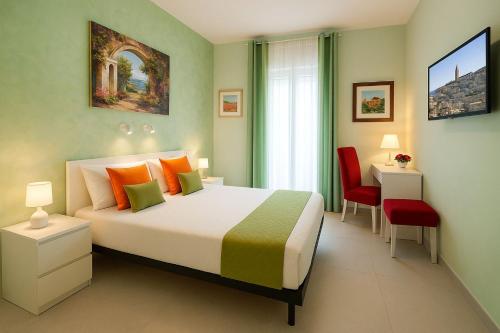 Un dormitorio con una cama grande y una silla roja. en Green House, en Matera