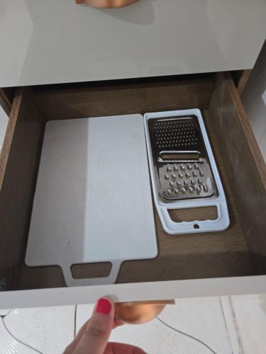 a persons hand is reaching into a box with a cell phone at Residencial Lima - Quarto 04 in São Luís