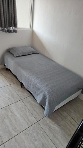 a bed sitting in a corner of a room at Residencial Lima - Quarto 04 in São Luís