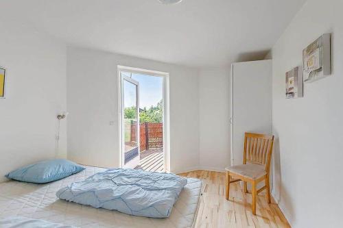a bedroom with a bed and a chair and a window at M12008-Vaeggerlose-Marielyst-Strandpark-112 in Marielyst